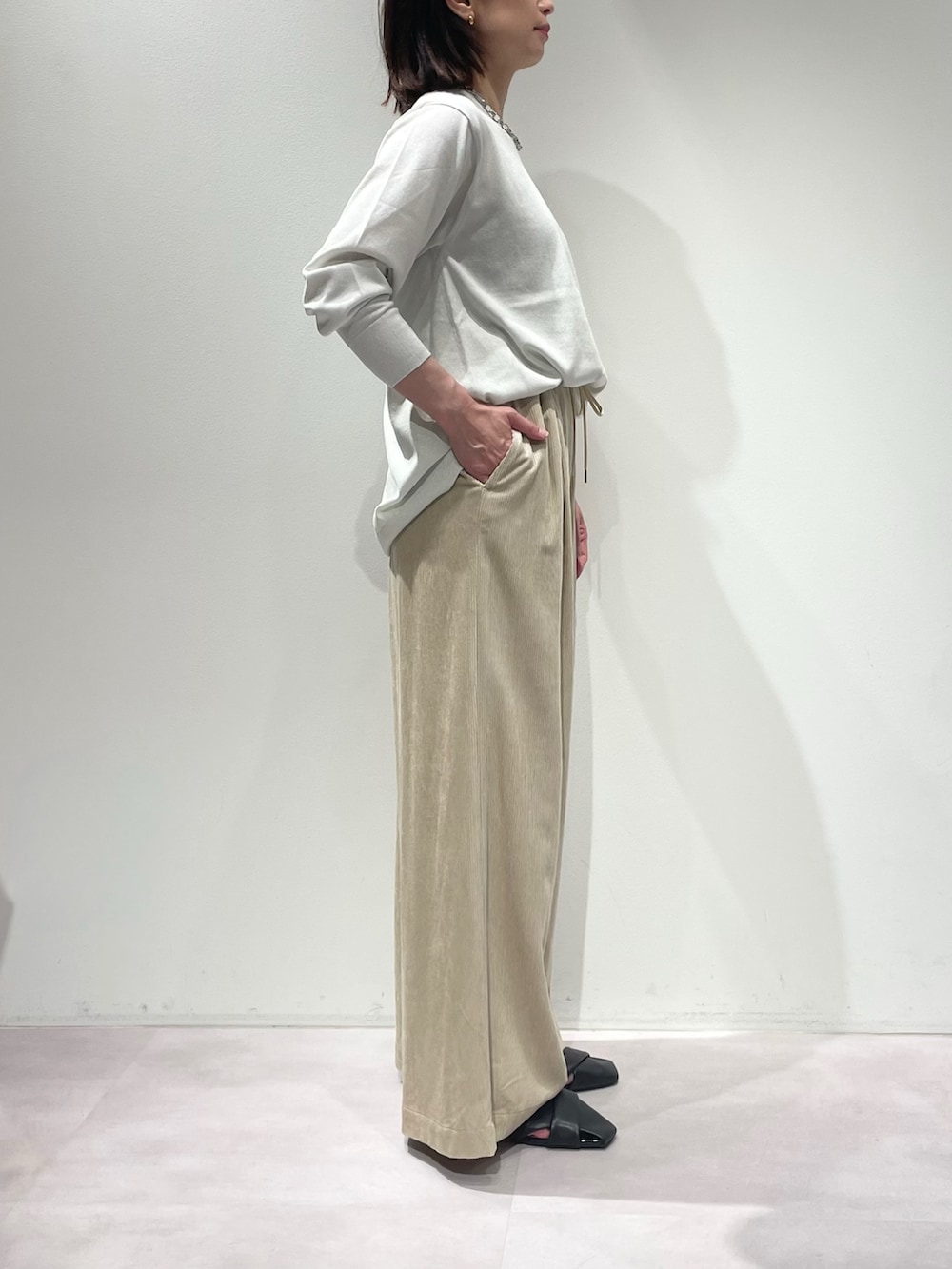 ベージュ系のその他パンツ、ホワイト系のニット/セーター、シルバー系のネックレスを着用したレディースの秋コーディネートの3枚目の写真