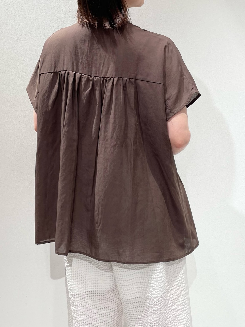 ブラウン系のシャツ/ブラウス、ホワイト系のその他パンツ、ブラウン系のネックレスを着用したレディースの夏コーディネートの6枚目の写真