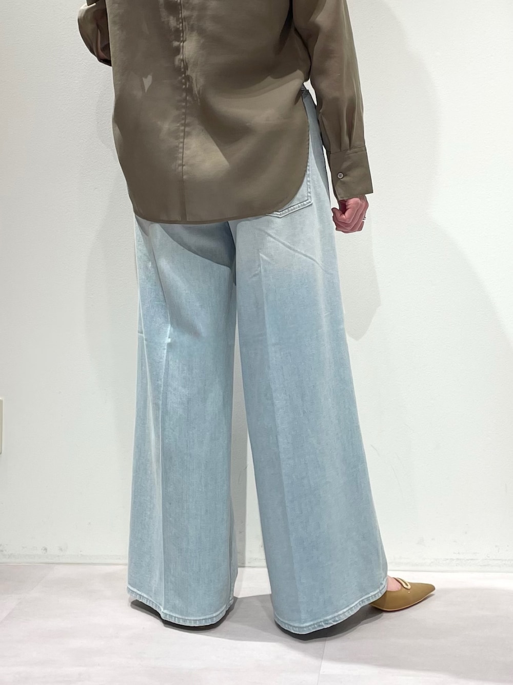 グリーン系のシャツ/ブラウス、ブルー系のデニムパンツ、ブラウン系のベルトを着用したレディースの冬コーディネートの9枚目の写真