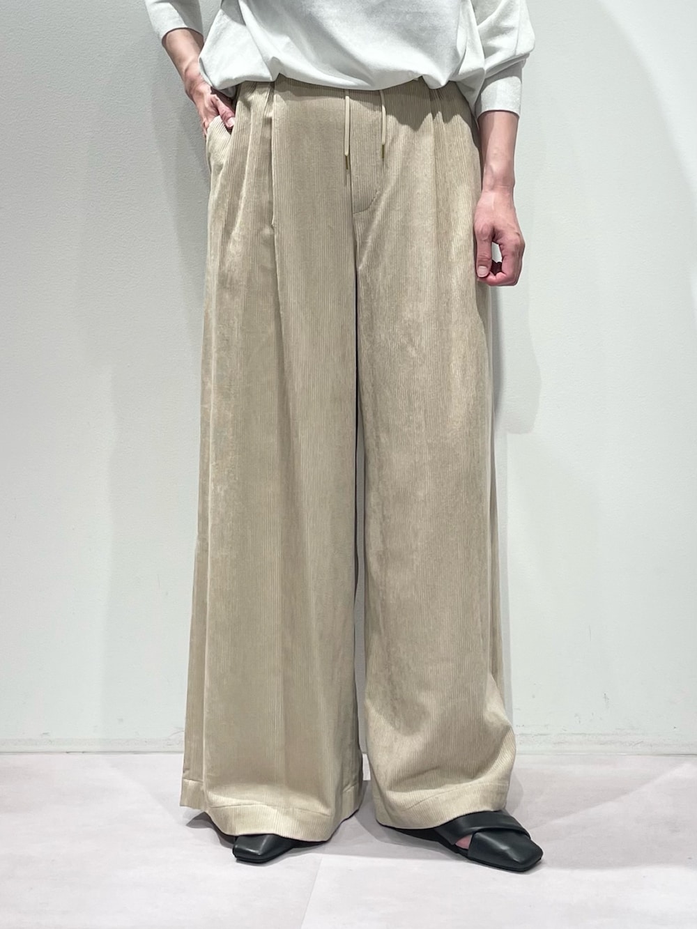 ベージュ系のその他パンツ、ホワイト系のニット/セーター、シルバー系のネックレスを着用したレディースの秋コーディネートの7枚目の写真