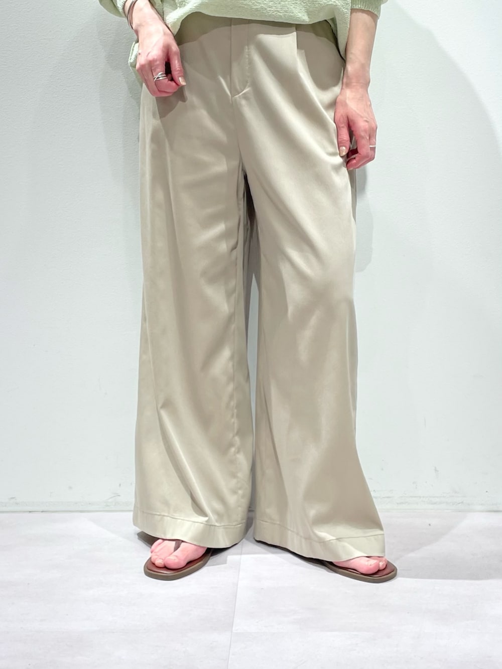 グリーン系のニット/セーター、ベージュ系のその他パンツ、シルバー系のネックレスを着用したレディースの春コーディネートの7枚目の写真