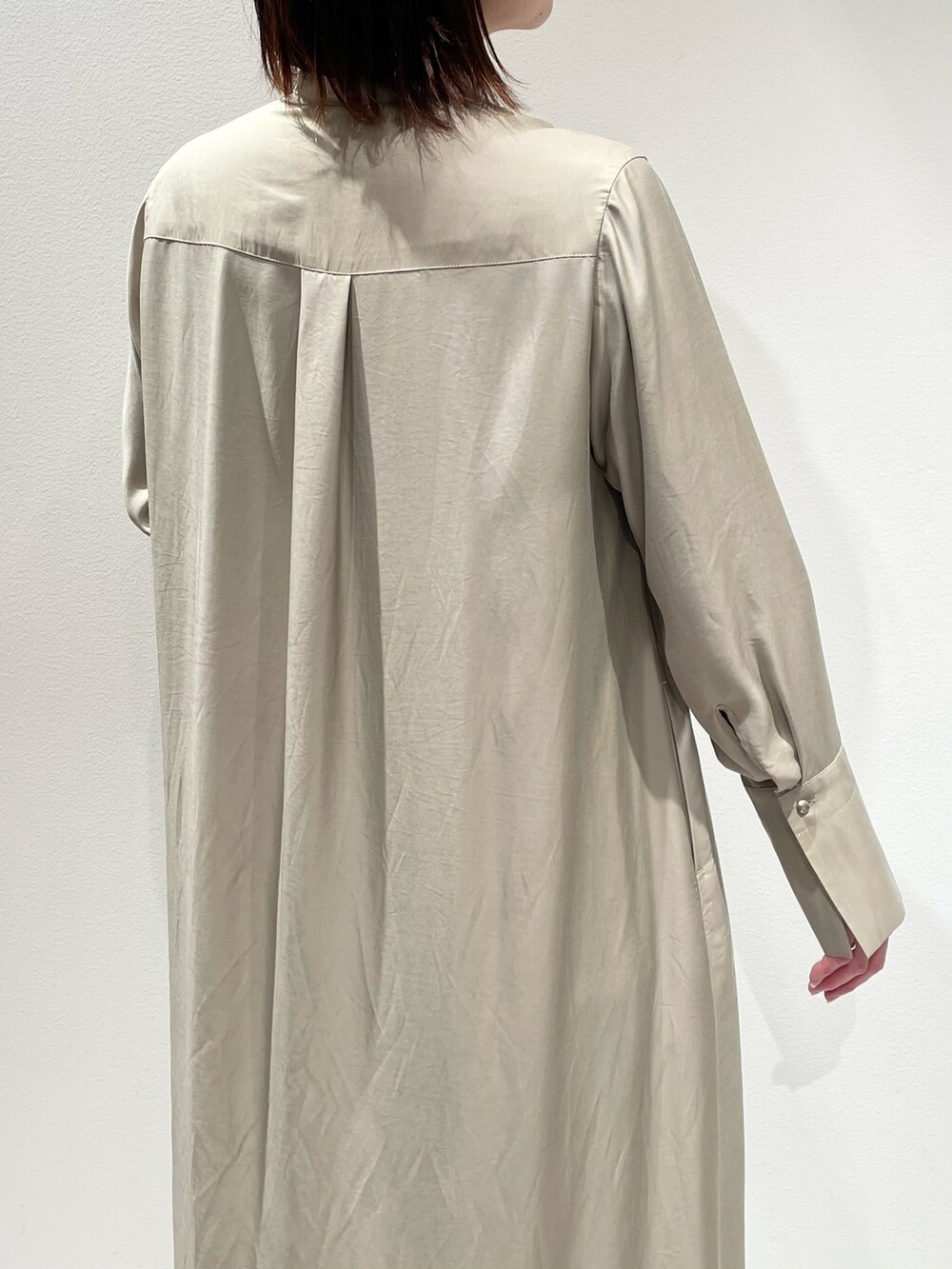 ベージュ系のワンピース、ブルー系のデニムパンツを着用したレディースの春コーディネートの6枚目の写真