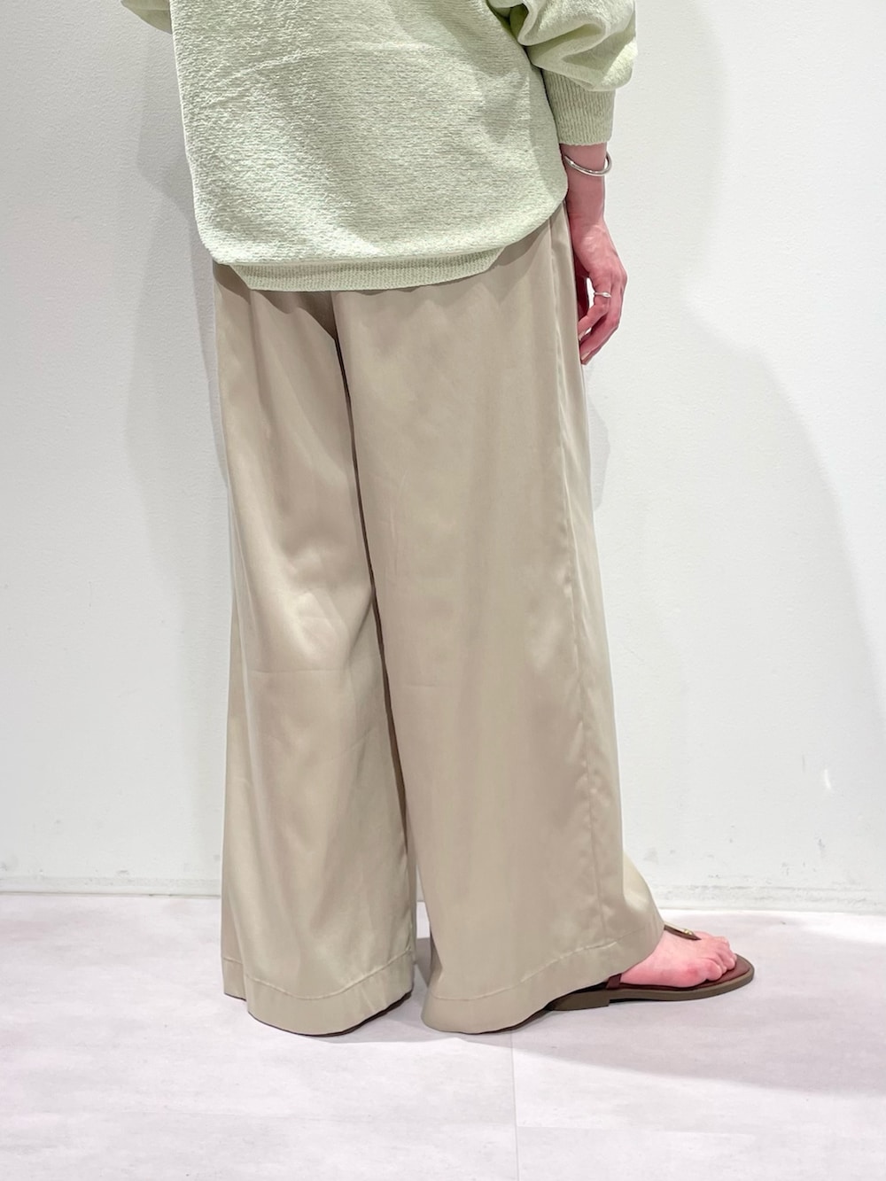グリーン系のニット/セーター、ベージュ系のその他パンツ、シルバー系のネックレスを着用したレディースの春コーディネートの9枚目の写真