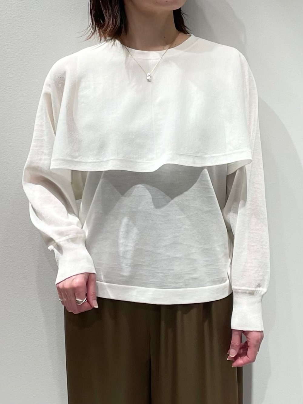 ホワイト系のニット/セーター、グリーン系のその他パンツ、ゴールド系のネックレスを着用したレディースの春コーディネートの4枚目の写真