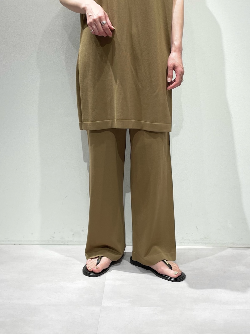 ベージュ系のその他パンツ、ベージュ系のニット/セーター、シルバー系のネックレスを着用したレディースの夏コーディネートの7枚目の写真