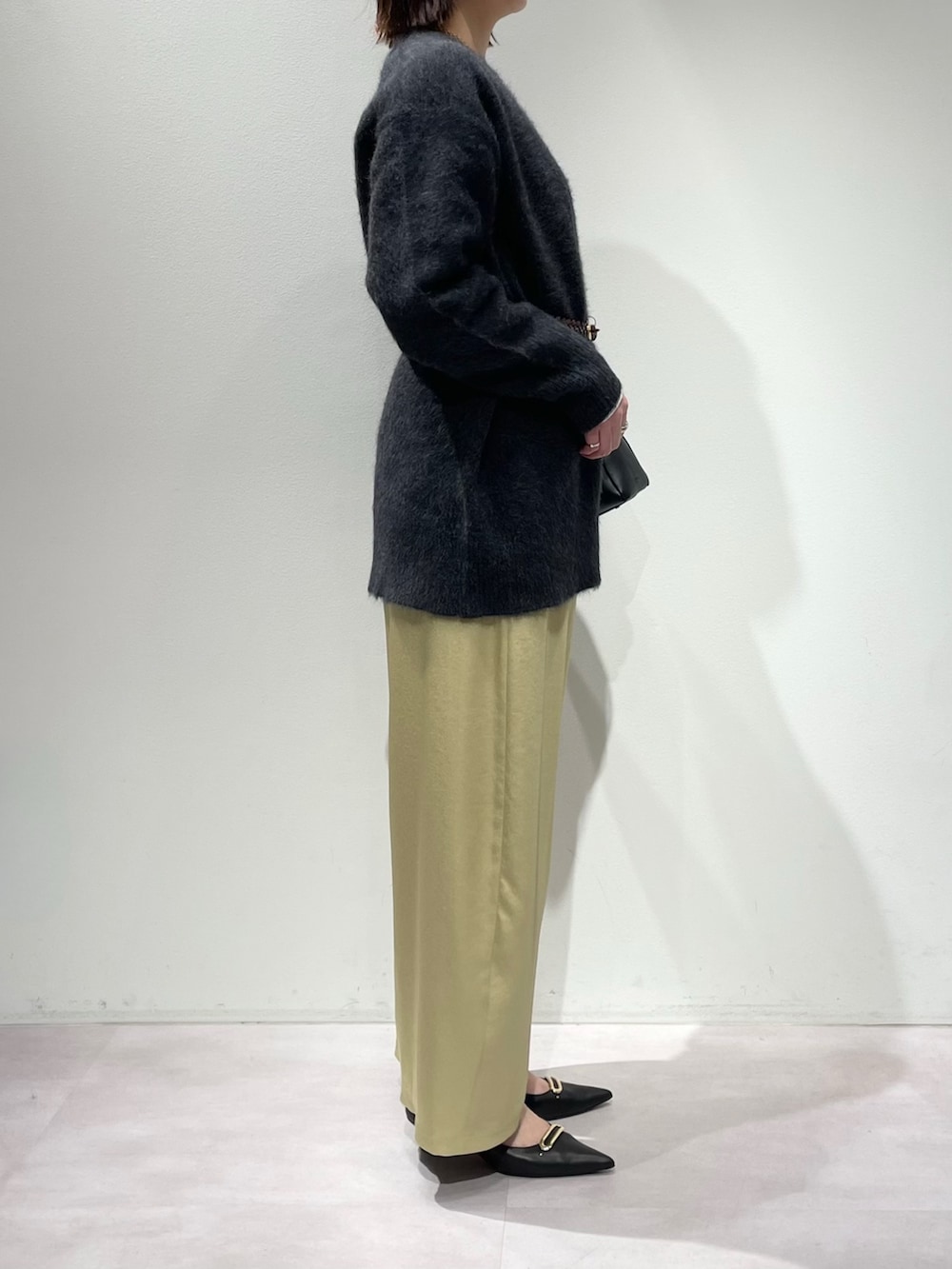イエロー系のその他パンツ、グレー系のカーディガン/ボレロ、ホワイト系のTシャツ/カットソーを着用したレディースの秋コーディネートの2枚目の写真