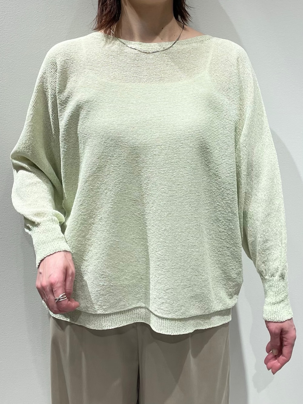 グリーン系のニット/セーター、ベージュ系のその他パンツ、シルバー系のネックレスを着用したレディースの春コーディネートの4枚目の写真