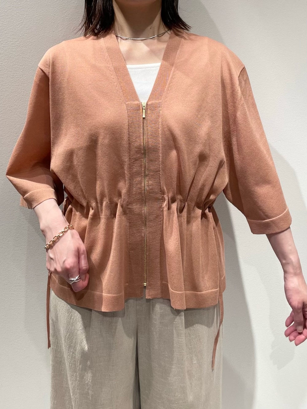 ベージュ系のその他パンツ、ピンク系のブルゾン、ホワイト系のニット/セーターを着用したレディースの夏コーディネートの4枚目の写真