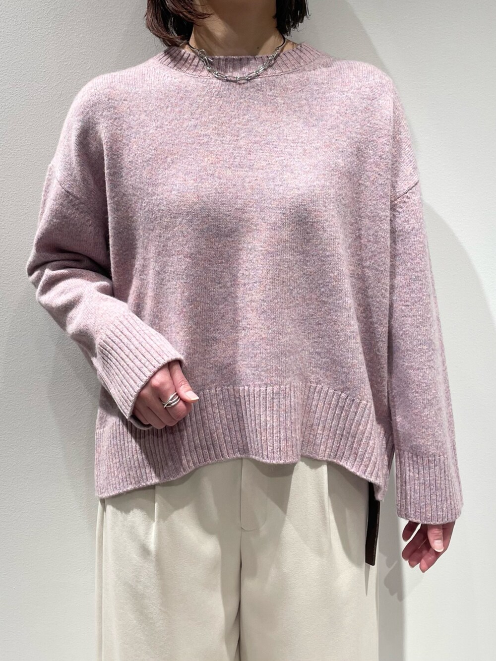 ピンク系のニット/セーター、ホワイト系のその他パンツ、シルバー系のネックレスを着用したレディースの冬コーディネートの4枚目の写真