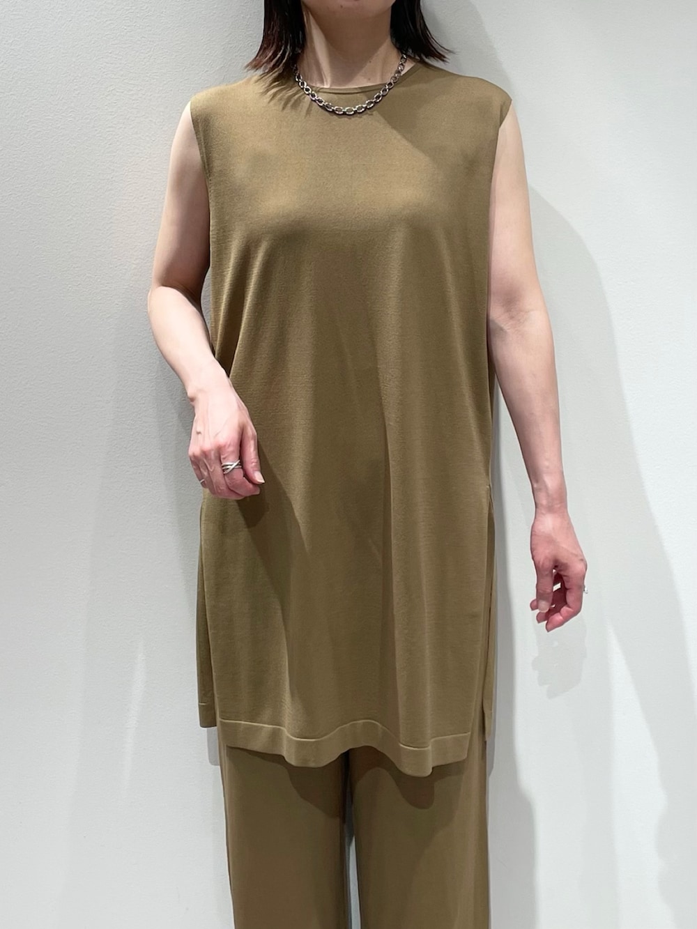 ベージュ系のその他パンツ、ベージュ系のニット/セーター、シルバー系のネックレスを着用したレディースの夏コーディネートの4枚目の写真