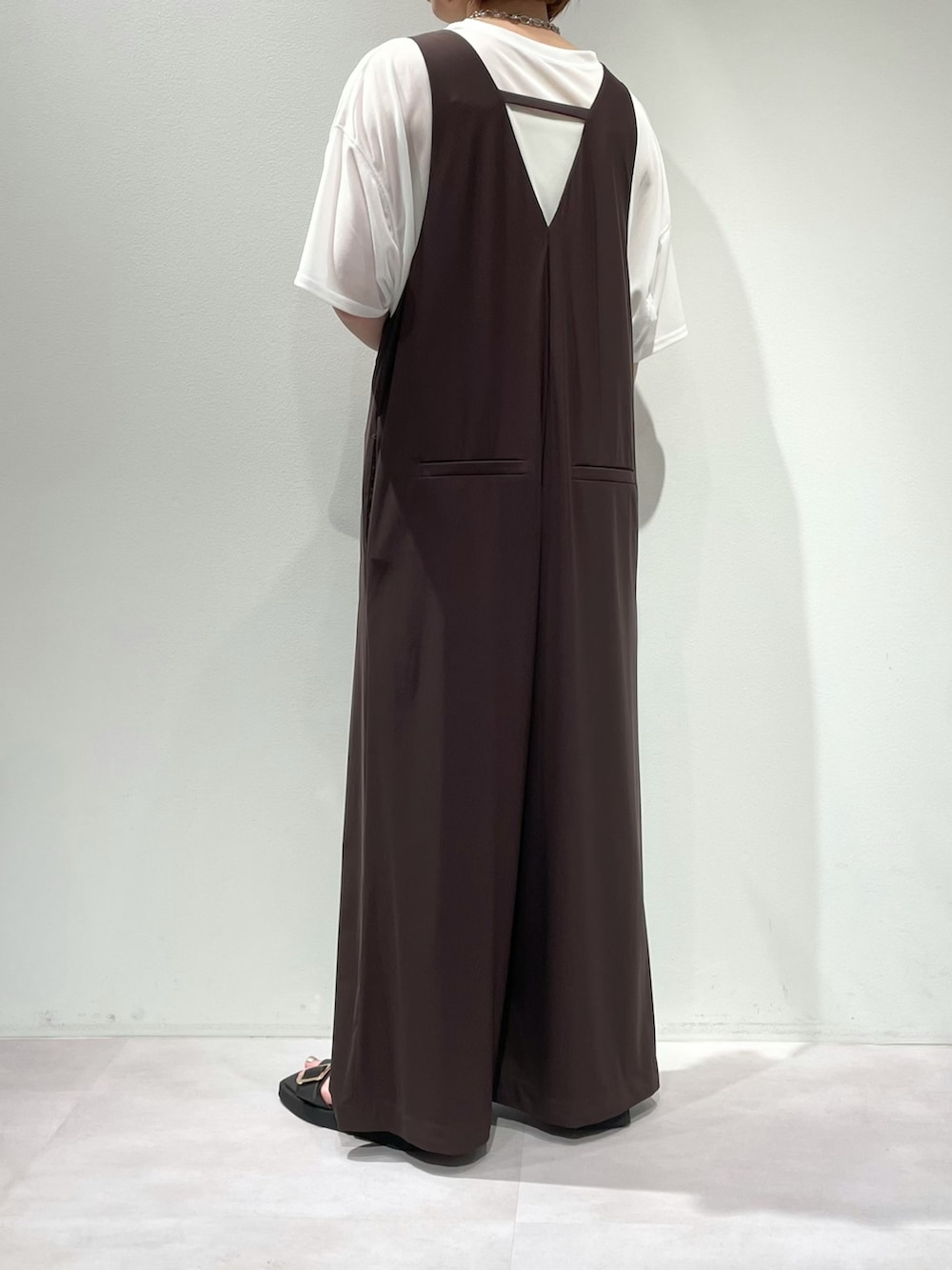 ホワイト系のTシャツ/カットソー、ブラック系のサンダル、ゴールド系のバングル/リストバンドを着用したレディースの夏コーディネートの2枚目の写真