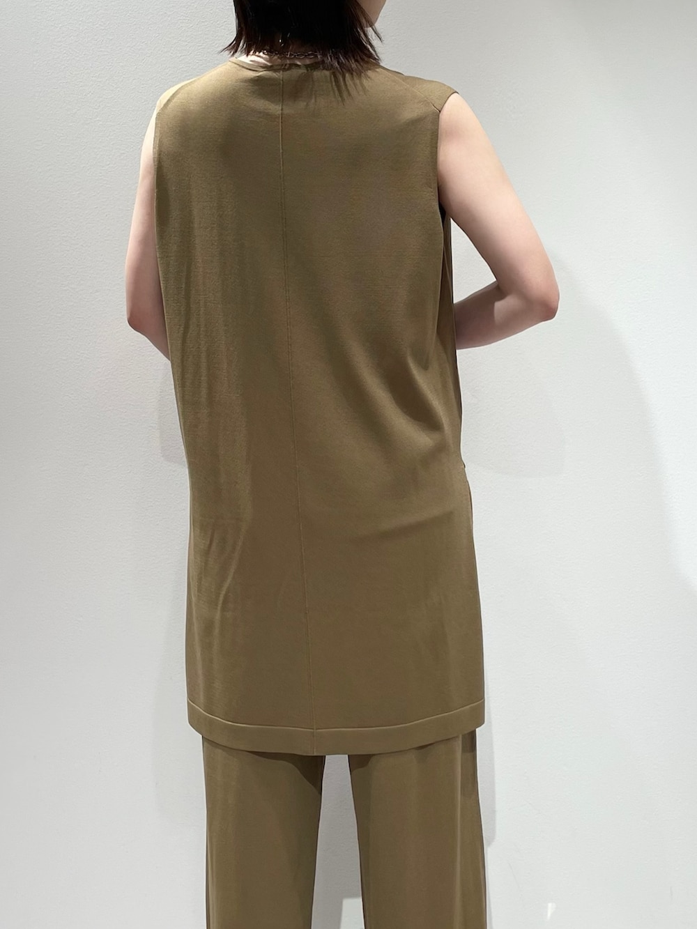 ベージュ系のその他パンツ、ベージュ系のニット/セーター、シルバー系のネックレスを着用したレディースの夏コーディネートの6枚目の写真