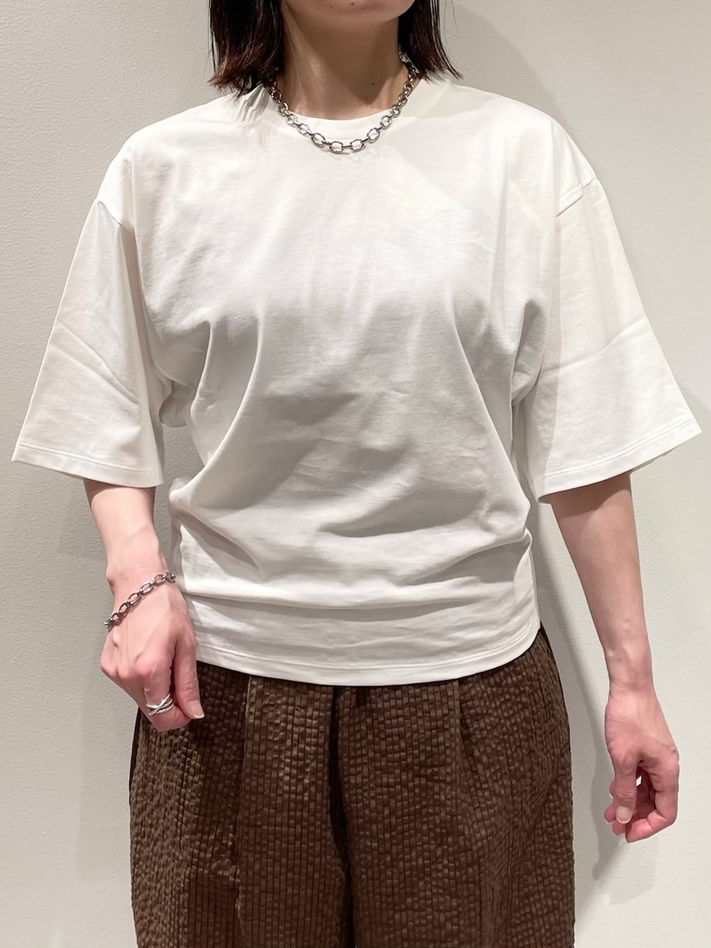ホワイト系のTシャツ/カットソー、ブラウン系のその他パンツ、ブラウン系のサンダルを着用したレディースの夏コーディネートの4枚目の写真