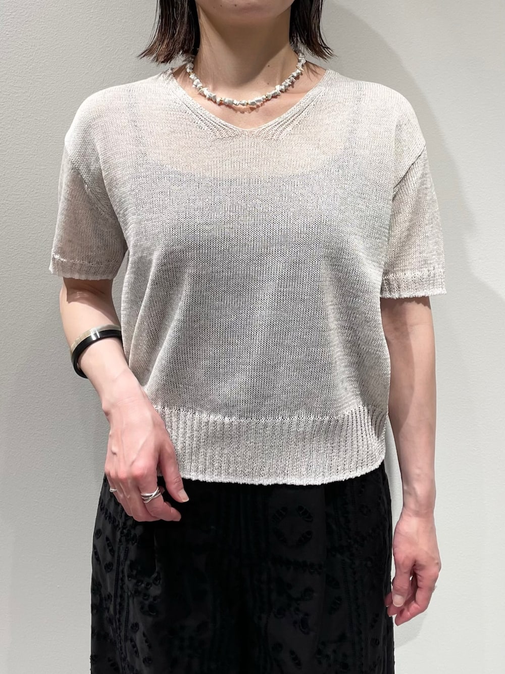 ブラック系のその他パンツ、ホワイト系のニット/セーター、ホワイト系のネックレスを着用したレディースの春コーディネートの4枚目の写真