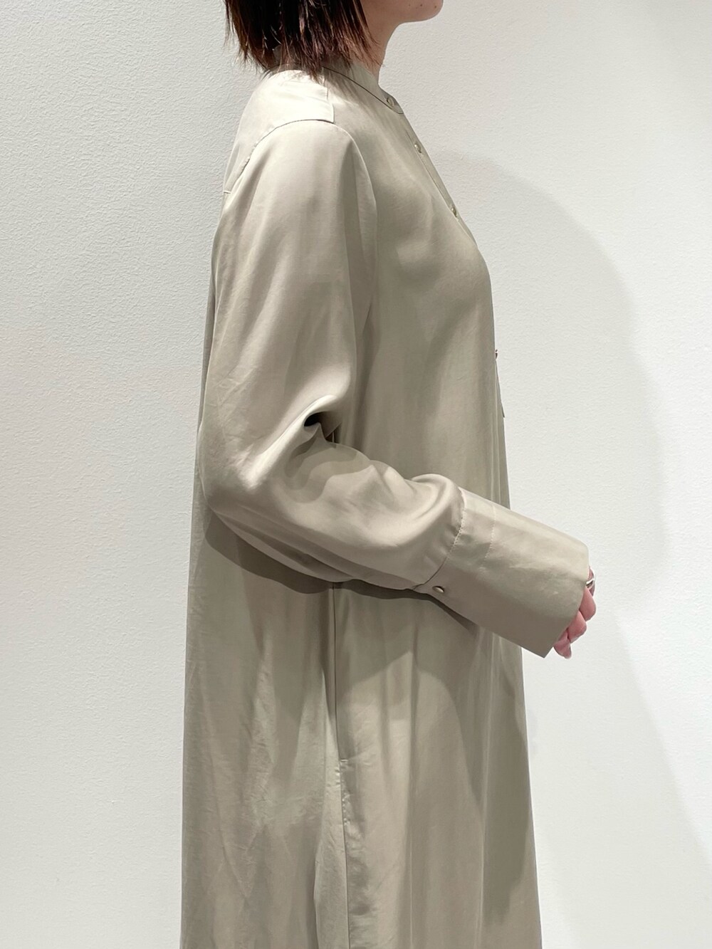 ベージュ系のワンピース、ブルー系のデニムパンツを着用したレディースの春コーディネートの5枚目の写真