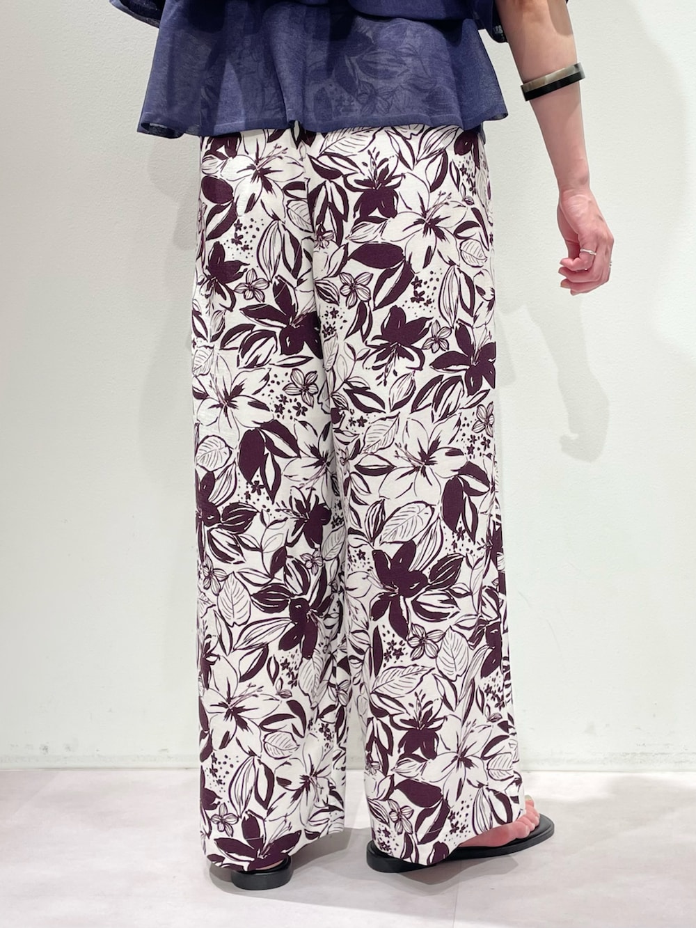 レッド系のその他パンツ、ブルー系のニット/セーター、シルバー系のネックレスを着用したレディースの春コーディネートの9枚目の写真