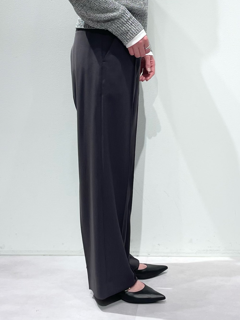 グレー系のその他パンツ、グレー系のニット/セーター、ホワイト系のTシャツ/カットソーを着用したレディースの春コーディネートの8枚目の写真