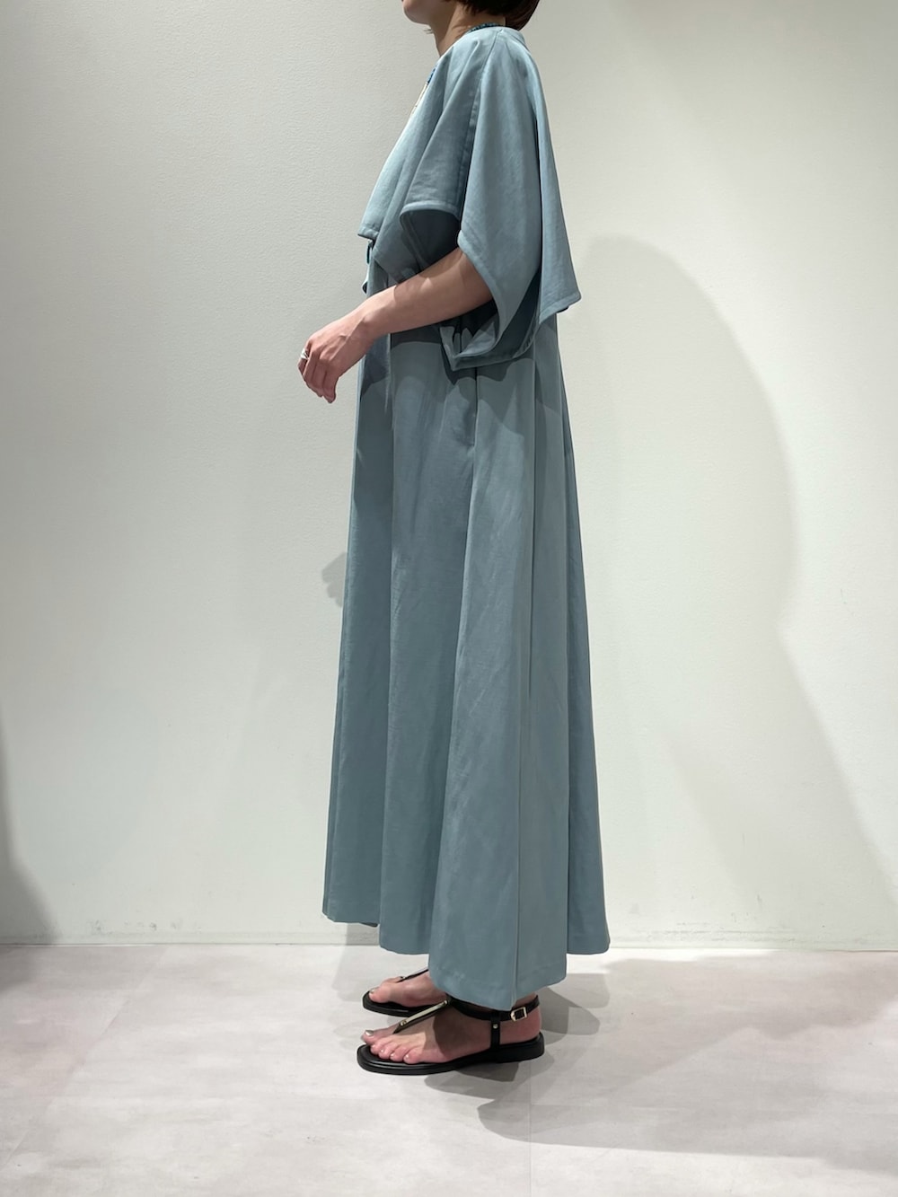 ブラウン系のサンダル、ブルー系のワンピース、ブラック系のショルダーバッグを着用したレディースの夏コーディネートの2枚目の写真