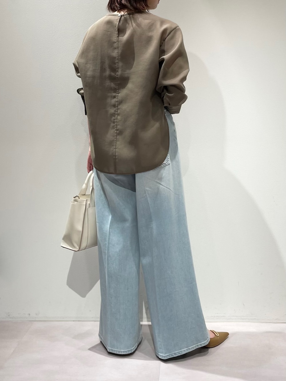 グリーン系のシャツ/ブラウス、ブルー系のデニムパンツ、ブラウン系のベルトを着用したレディースの冬コーディネートの3枚目の写真