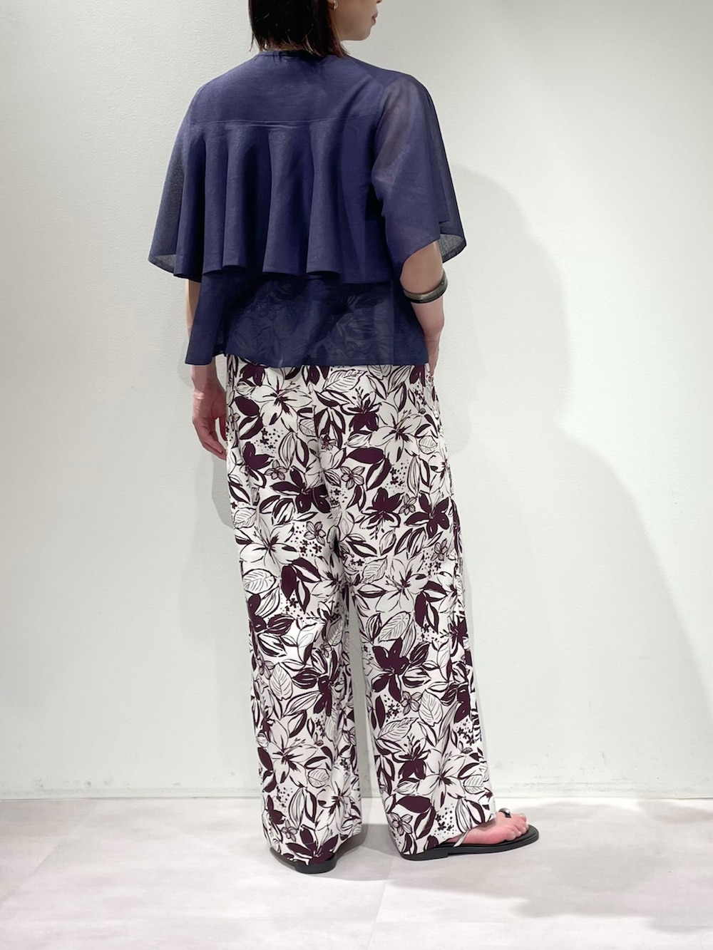 レッド系のその他パンツ、ブルー系のニット/セーター、シルバー系のネックレスを着用したレディースの春コーディネートの3枚目の写真