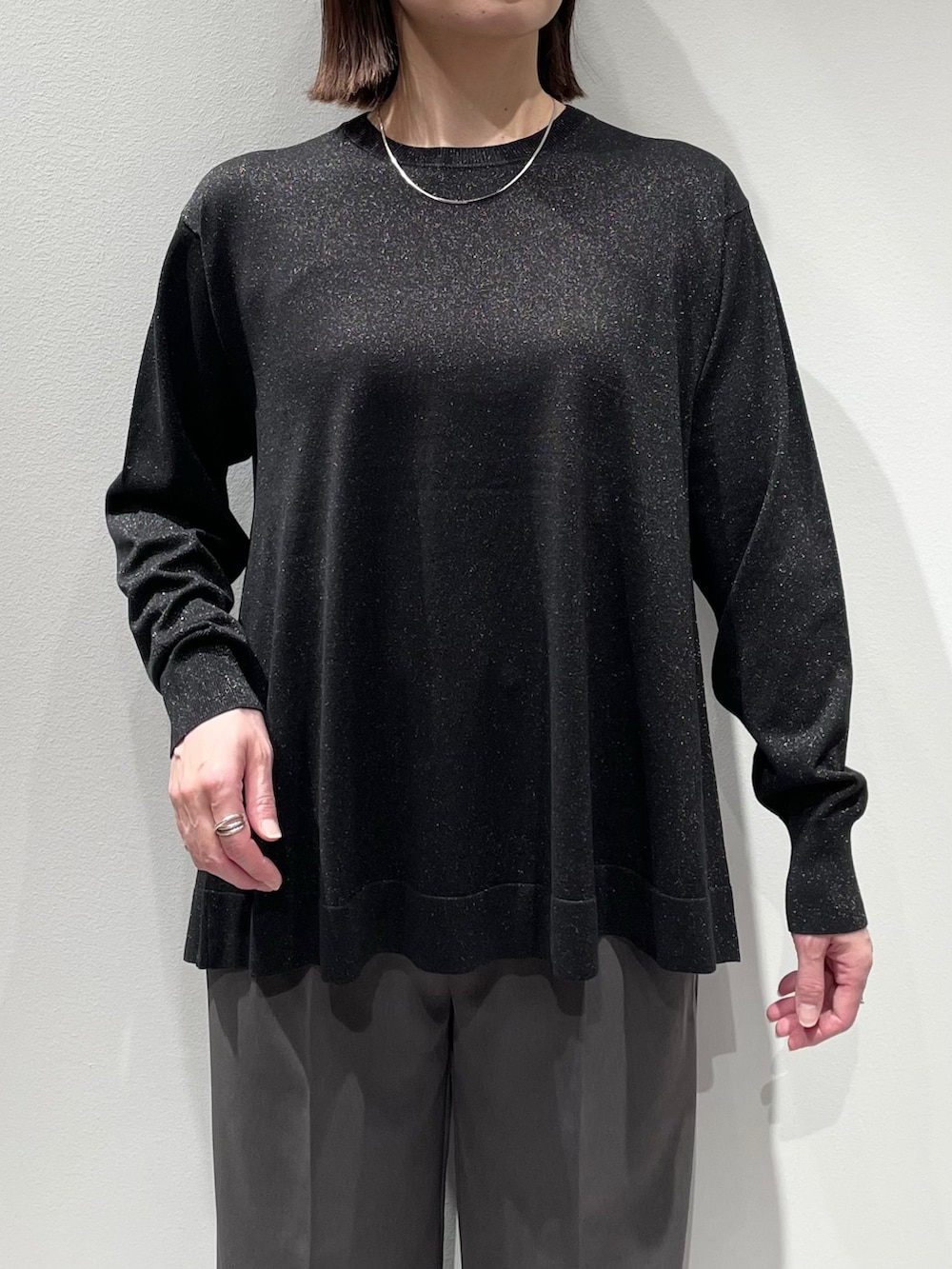 ブラック系のニット/セーター、グレー系のその他パンツ、シルバー系のネックレスを着用したレディースの秋コーディネートの4枚目の写真
