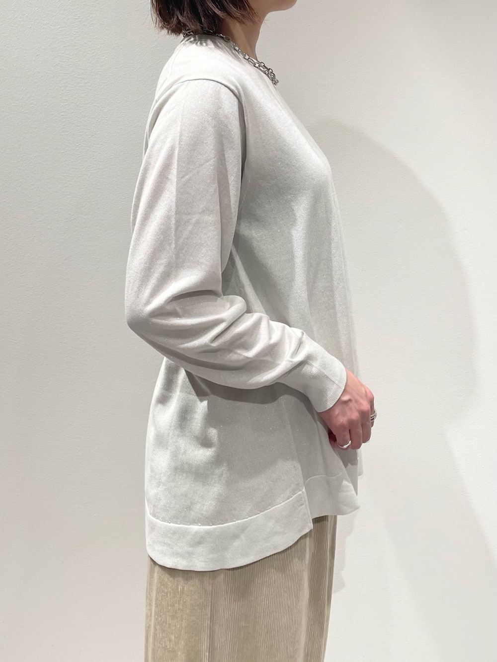ベージュ系のその他パンツ、ホワイト系のニット/セーター、シルバー系のネックレスを着用したレディースの秋コーディネートの5枚目の写真