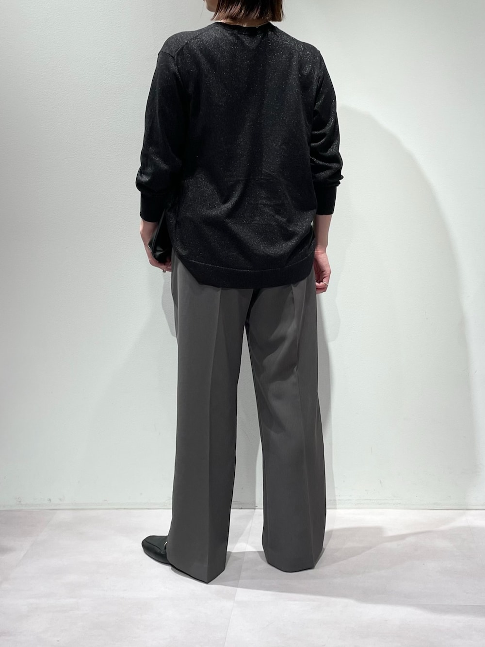 ブラック系のニット/セーター、グレー系のその他パンツ、シルバー系のネックレスを着用したレディースの秋コーディネートの3枚目の写真