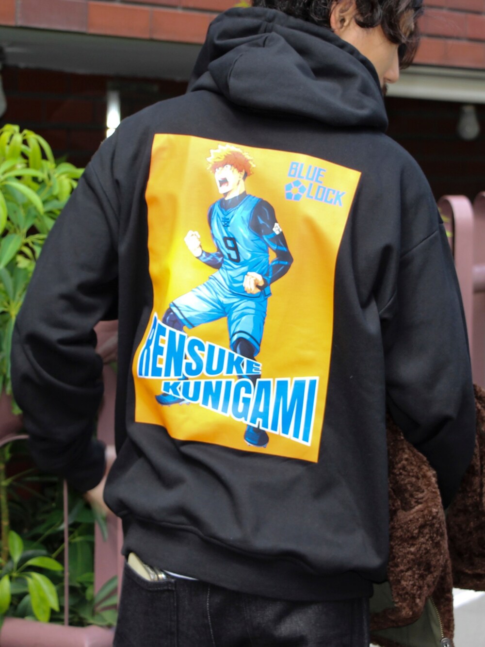 ブラウン系のベスト、ブラック系のパーカー、ブラック系のデニムパンツを着用したメンズの秋コーディネートの3枚目の写真