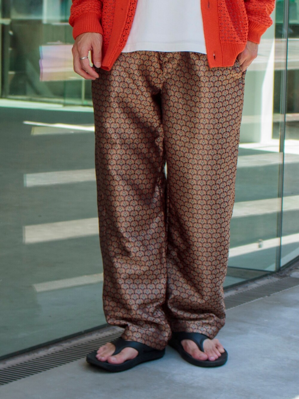 オレンジ系のカーディガン/ボレロ、ベージュ系のその他パンツ、ブラック系のサンダルを着用したメンズの夏コーディネートの3枚目の写真