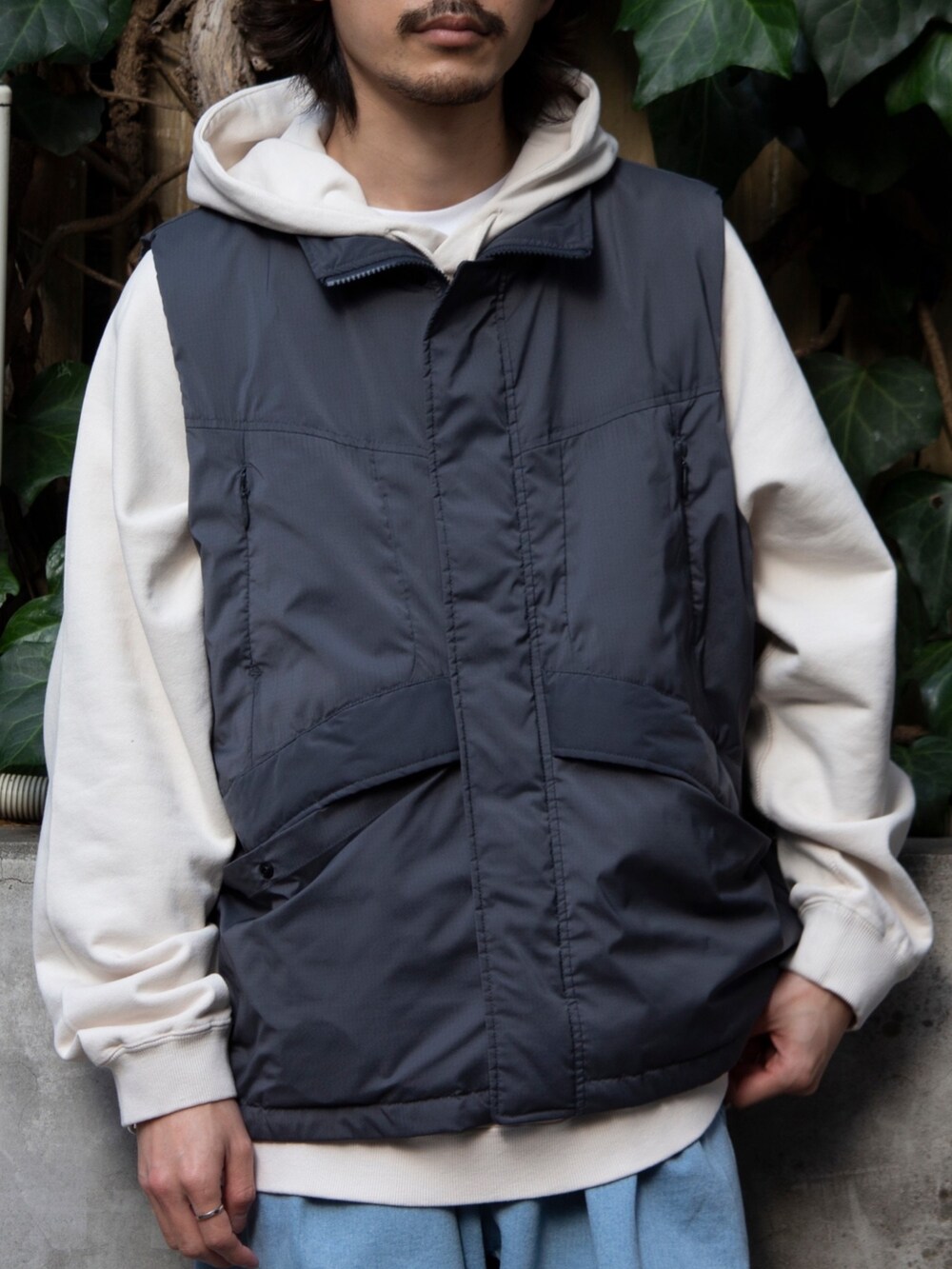 グレー系のベスト、ベージュ系のパーカー、ブルー系のその他パンツを着用したメンズの春コーディネートの6枚目の写真