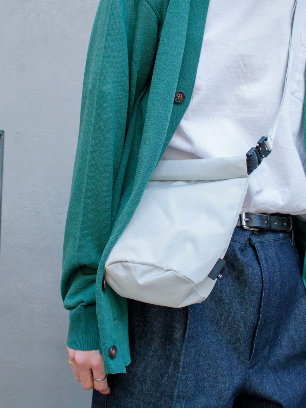 グリーン系のカーディガン/ボレロ、ブルー系のその他パンツ、ブラック系のスニーカーを着用したメンズの冬コーディネートの3枚目の写真