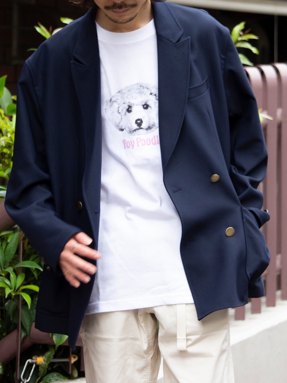 ホワイト系のデニムパンツ、ブラック系のサンダル、ブルー系のテーラードジャケットを着用したメンズの春コーディネートの2枚目の写真