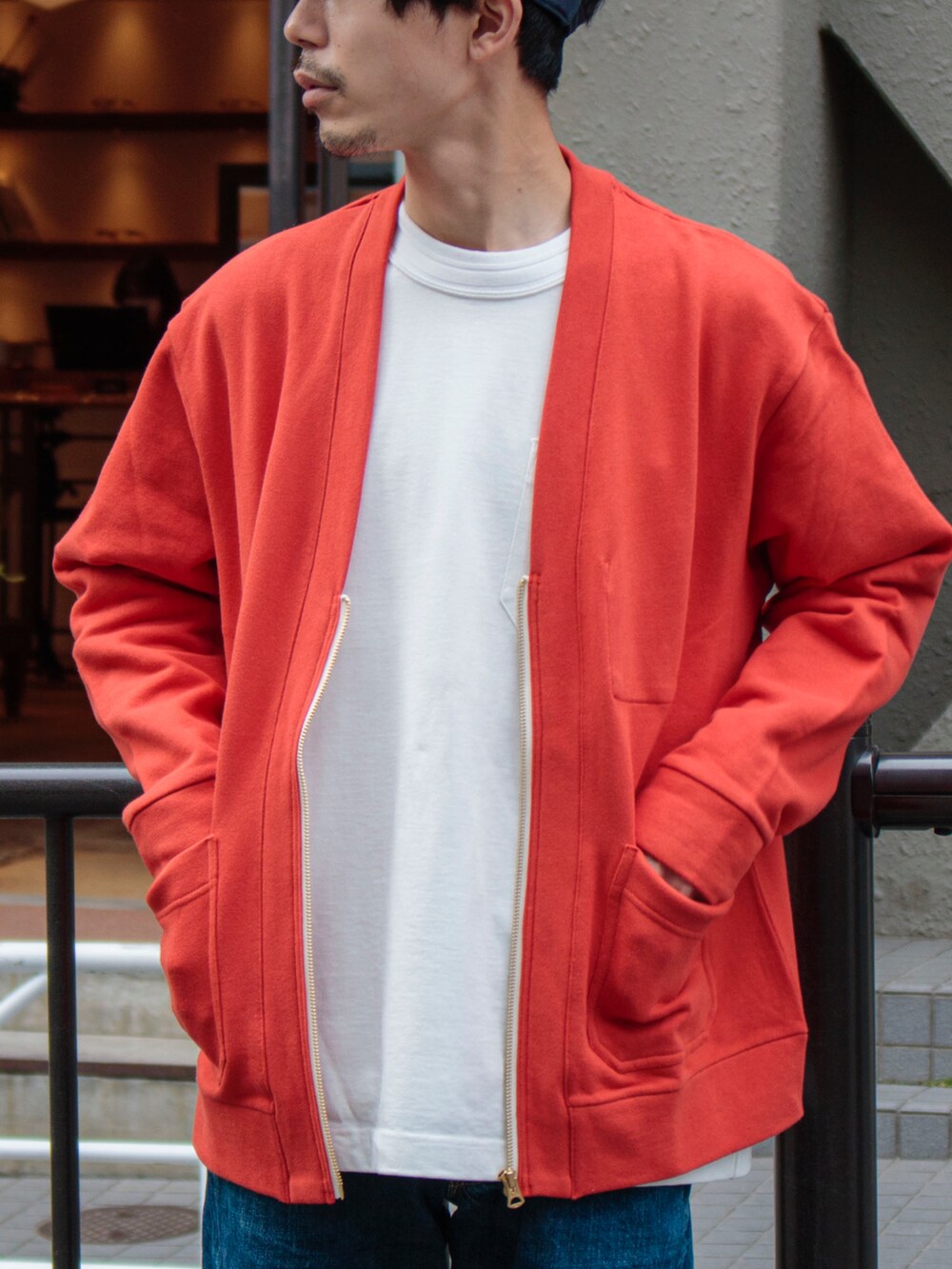 ブルー系のパンツ、ホワイト系のTシャツ/カットソー、オレンジ系のカーディガン/ボレロを着用したメンズの春コーディネートの2枚目の写真