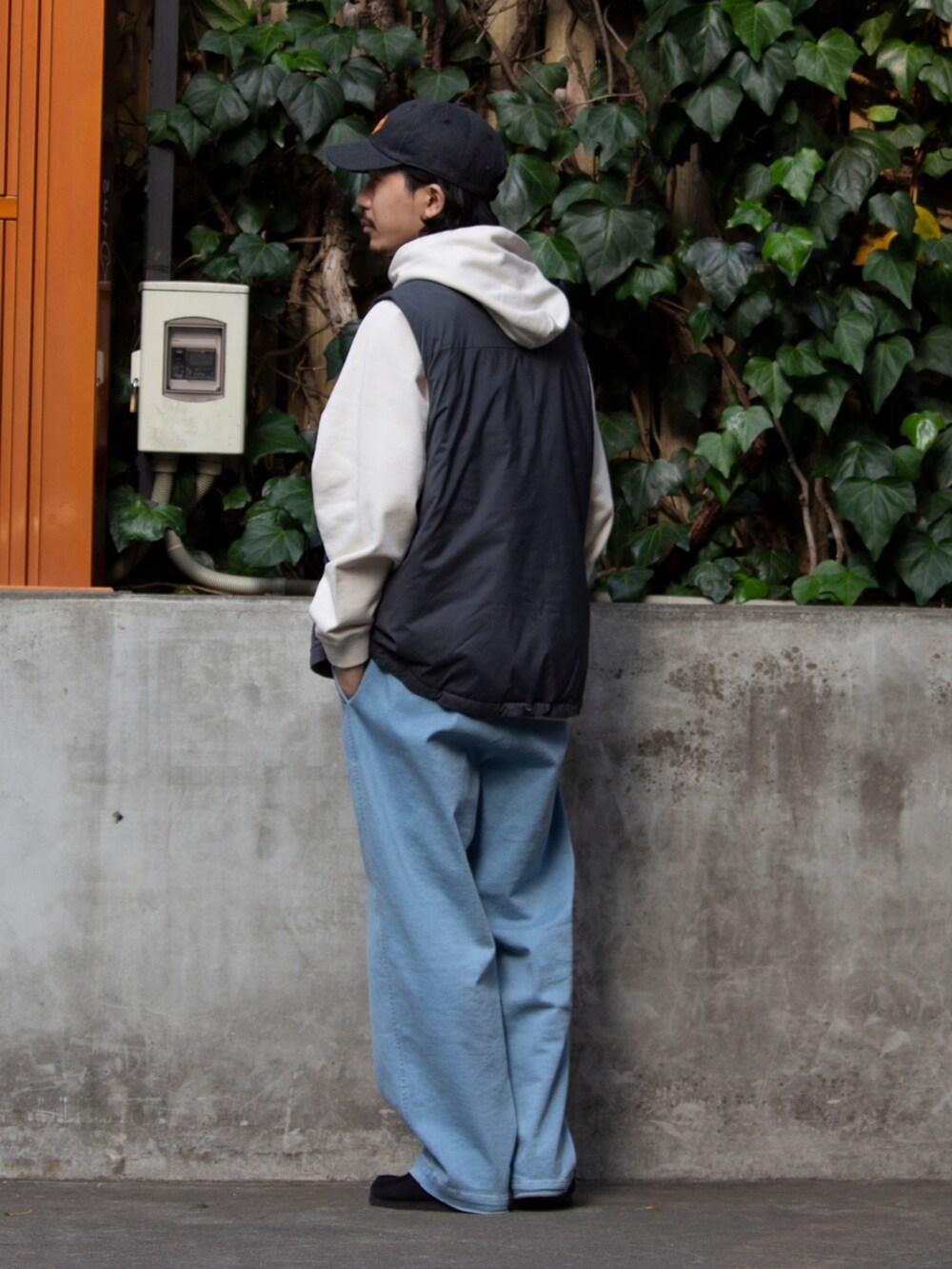 グレー系のベスト、ベージュ系のパーカー、ブルー系のその他パンツを着用したメンズの春コーディネートの2枚目の写真