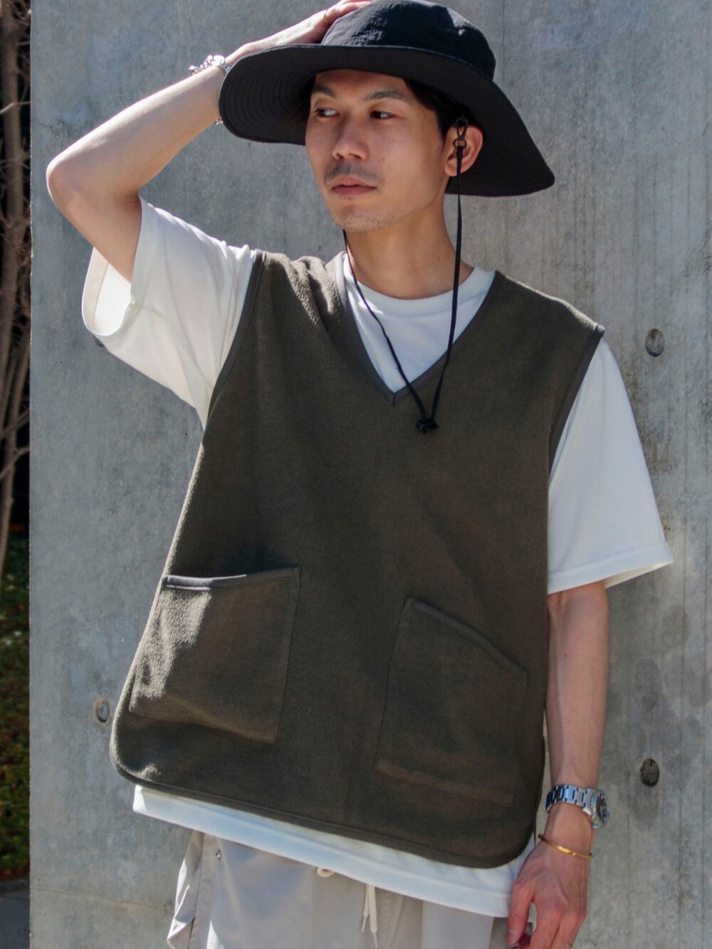 グリーン系のベスト、ホワイト系のTシャツ/カットソー、ベージュ系のその他パンツを着用したメンズの春コーディネートの2枚目の写真