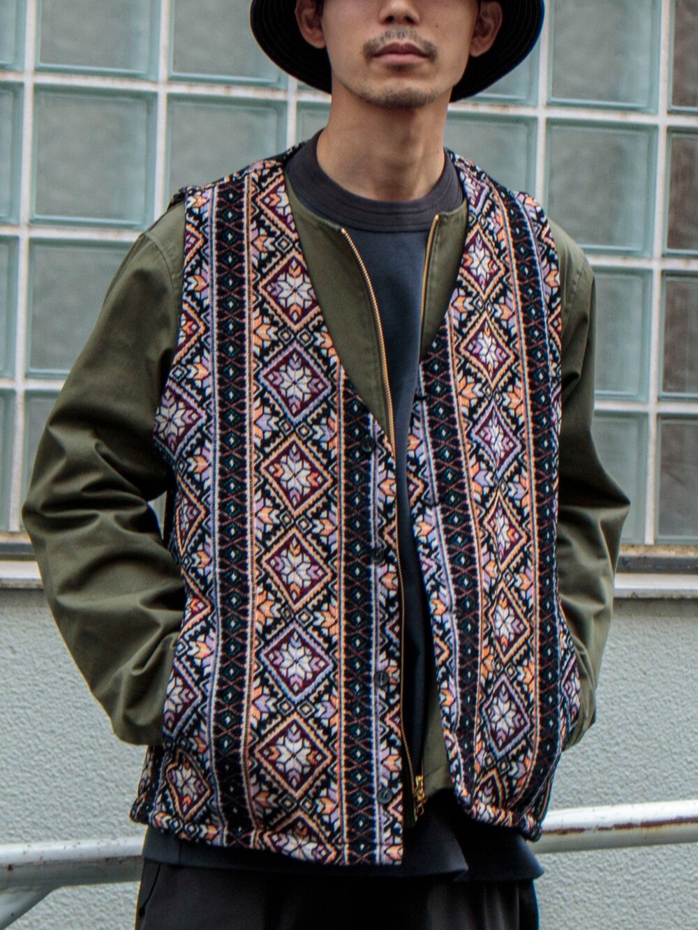 ブラック系のベスト、グリーン系のブルゾン、グレー系のTシャツ/カットソーを着用したメンズの春コーディネートの2枚目の写真