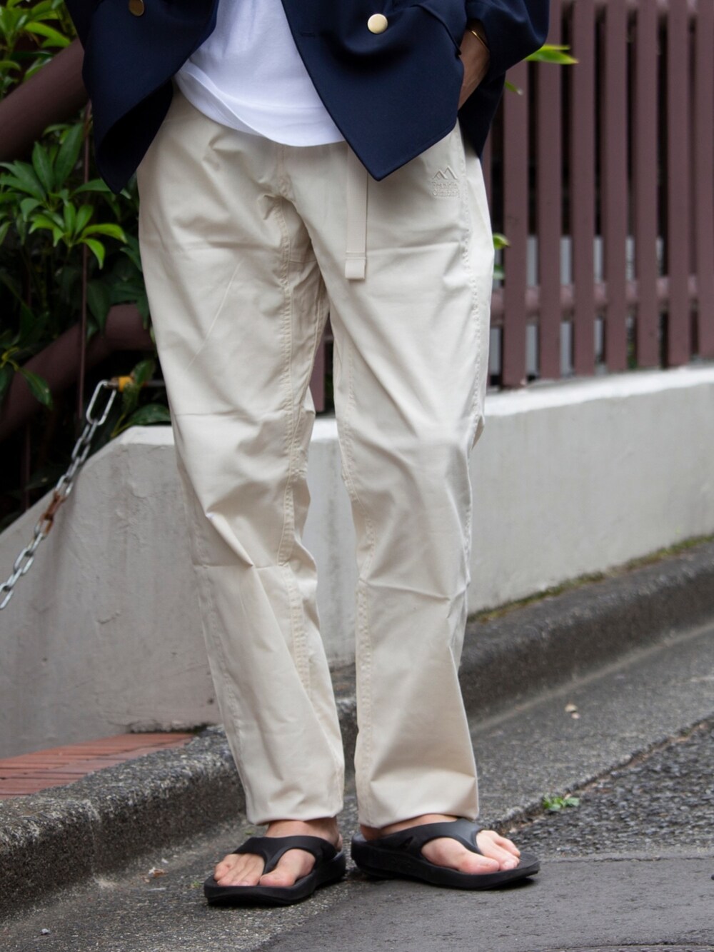 ホワイト系のデニムパンツ、ブラック系のサンダル、ブルー系のテーラードジャケットを着用したメンズの春コーディネートの4枚目の写真