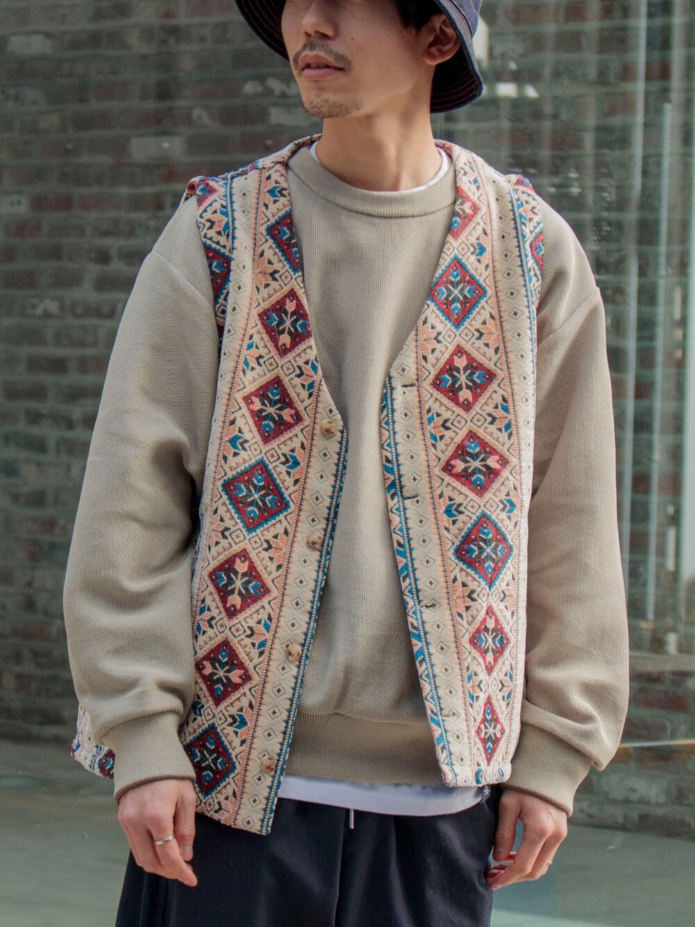 ホワイト系のベスト、ベージュ系のニット/セーター、ブルー系のその他パンツを着用したメンズの冬コーディネートの2枚目の写真