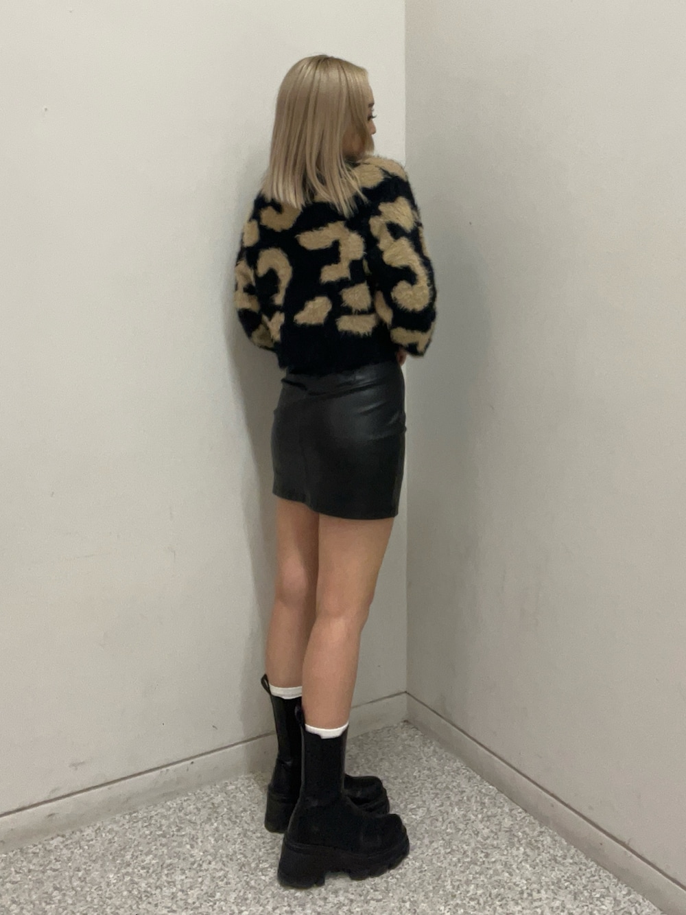 ブラック系のニット/セーター、その他のスカート、ブラック系のブーツを着用したレディースの冬コーディネートの2枚目の写真