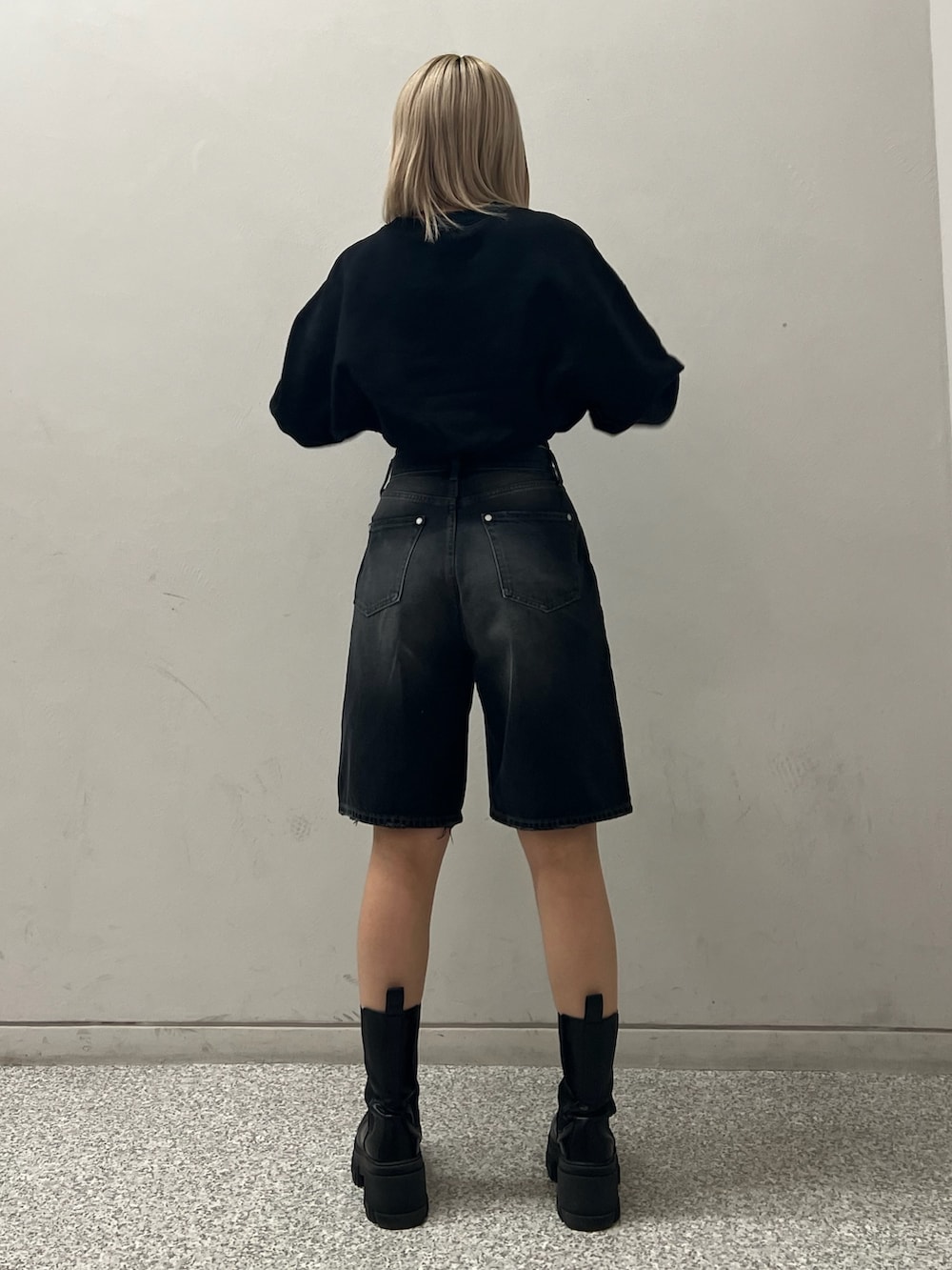 ブラック系のデニムパンツ、ブラック系のブーツ、ブラック系のTシャツ/カットソーを着用したレディースの冬コーディネートの3枚目の写真