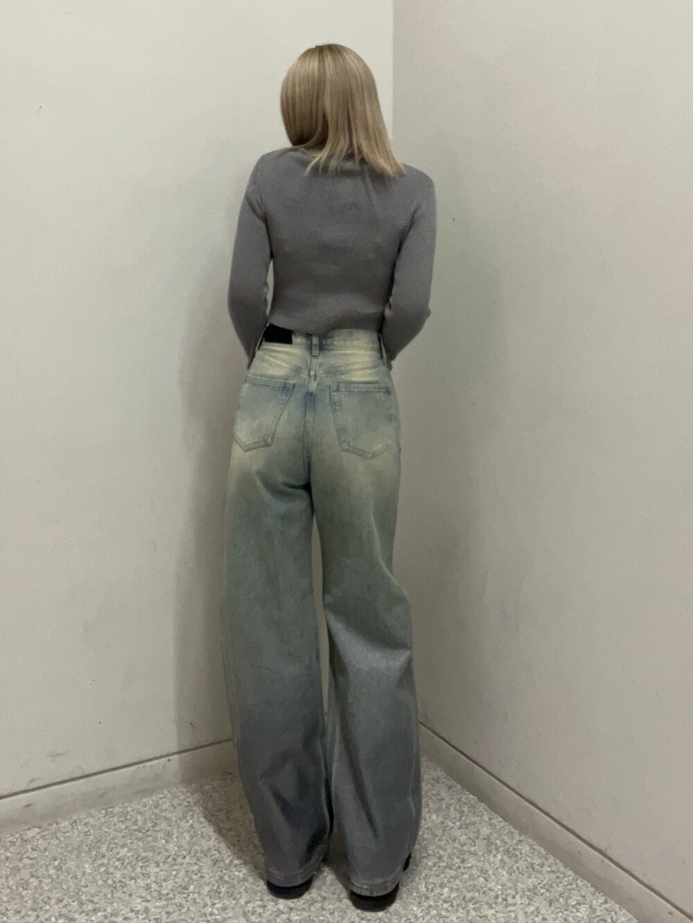 ブルー系のデニムパンツ、シルバー系のニット/セーター、ブラック系のブーツを着用したレディースの冬コーディネートの3枚目の写真