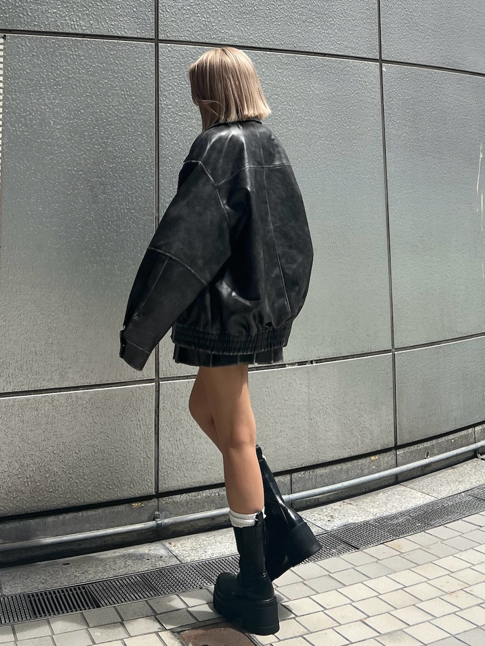 ブラック系のタンクトップ、グレー系のブルゾン、グレー系のスカートを着用したレディースの秋コーディネートの4枚目の写真