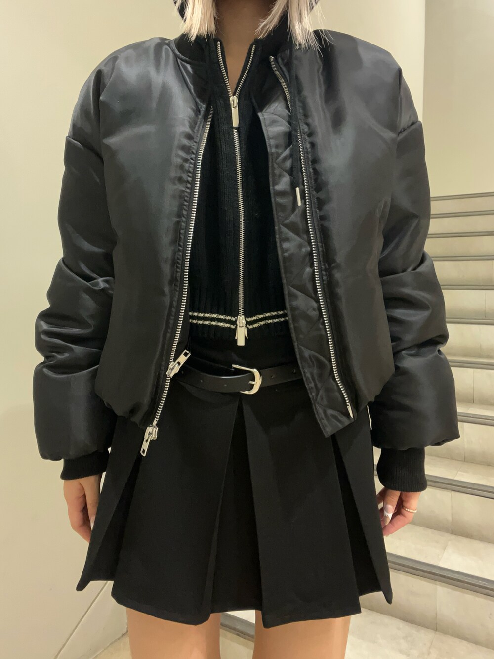 ブラック系のブルゾン、ブラック系のニット/セーター、ブラック系のスカートを着用したレディースの秋コーディネートの4枚目の写真