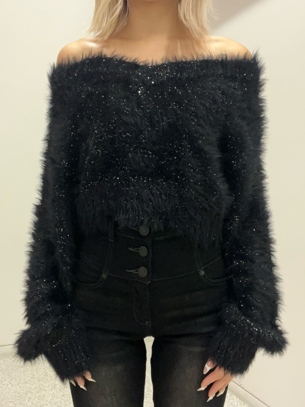 ブラック系のニット/セーター、ブラック系のデニムパンツ、ブラック系のブーツを着用したレディースの秋コーディネートの4枚目の写真