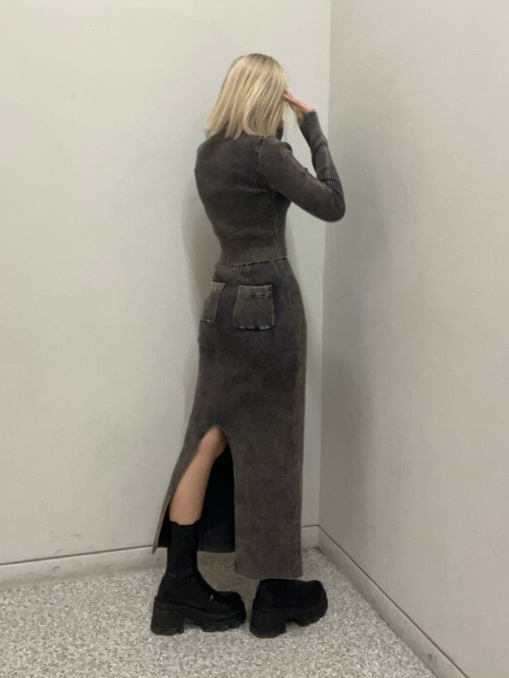 ブラック系のニット/セーター、ブラック系のスカート、ブラック系のブーツを着用したレディースの冬コーディネートの2枚目の写真