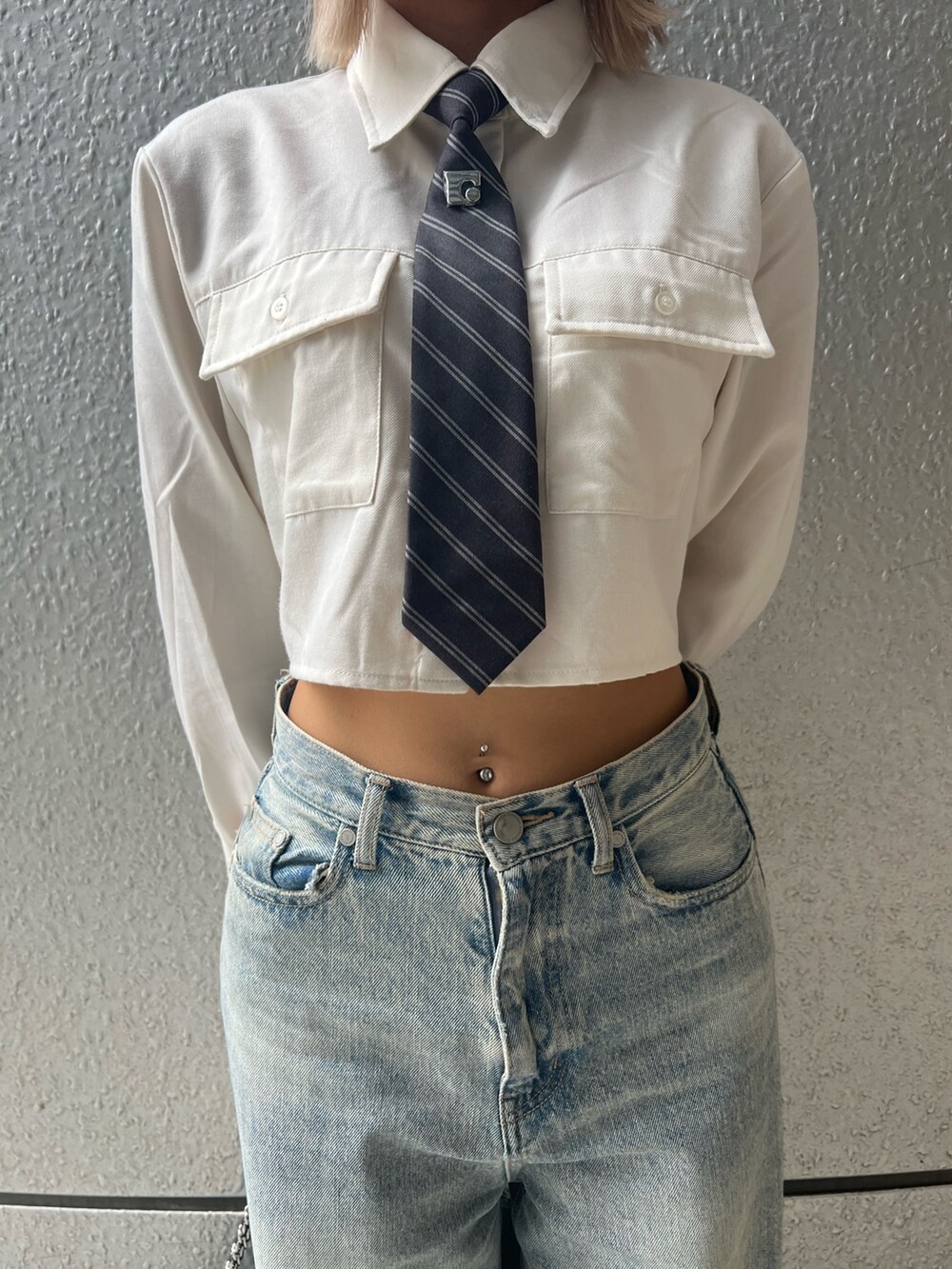 ブルー系のデニムパンツ、ホワイト系のシャツ/ブラウス、ブラック系のブーツを着用したレディースの秋コーディネートの5枚目の写真