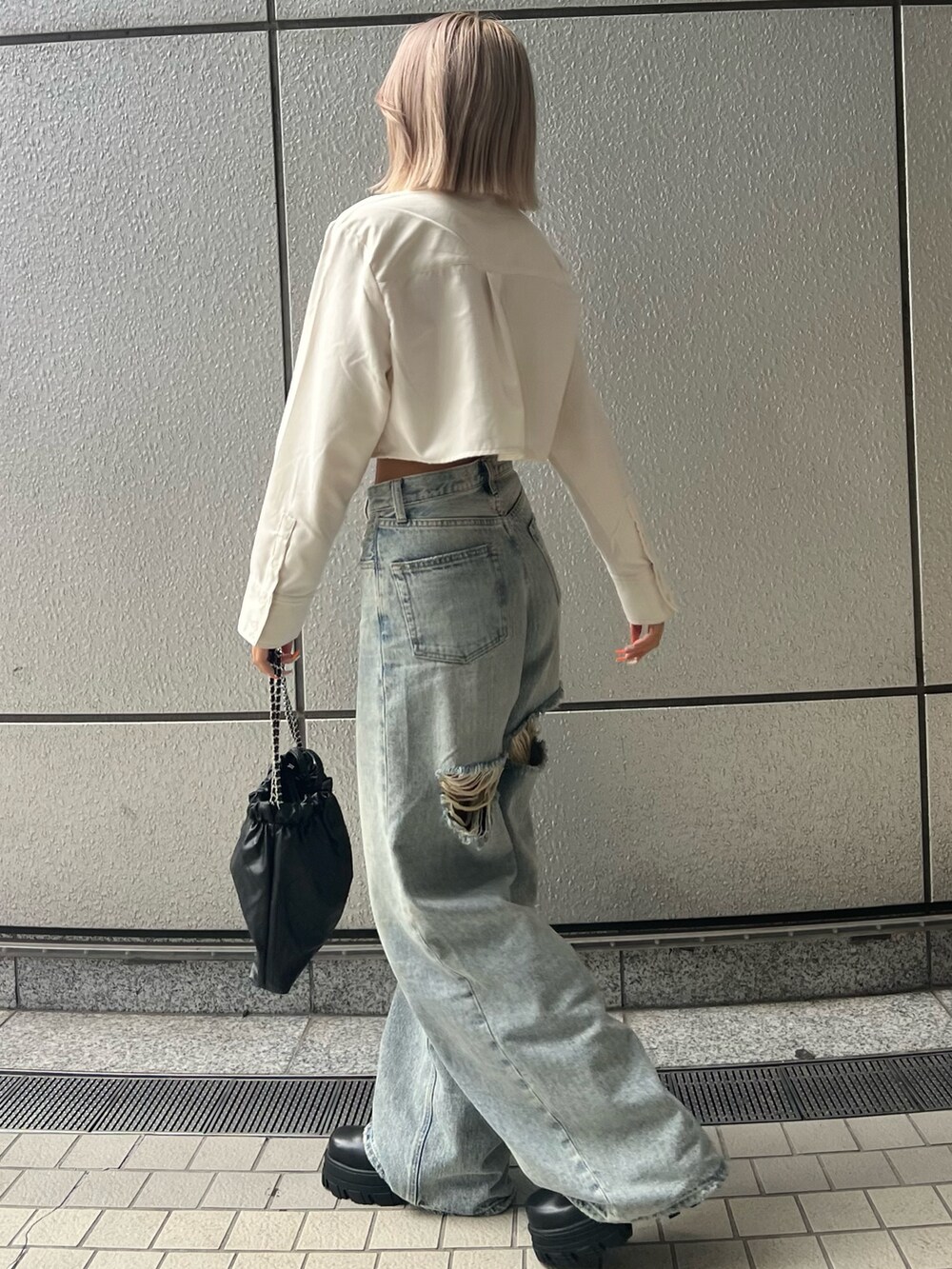 ブルー系のデニムパンツ、ホワイト系のシャツ/ブラウス、ブラック系のブーツを着用したレディースの秋コーディネートの3枚目の写真