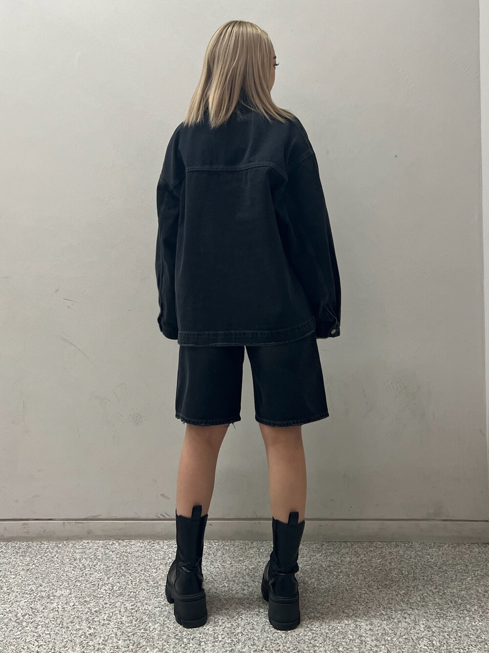 ブラック系のブルゾン、ブラック系のデニムパンツ、グレー系のニット/セーターを着用したレディースの冬コーディネートの3枚目の写真