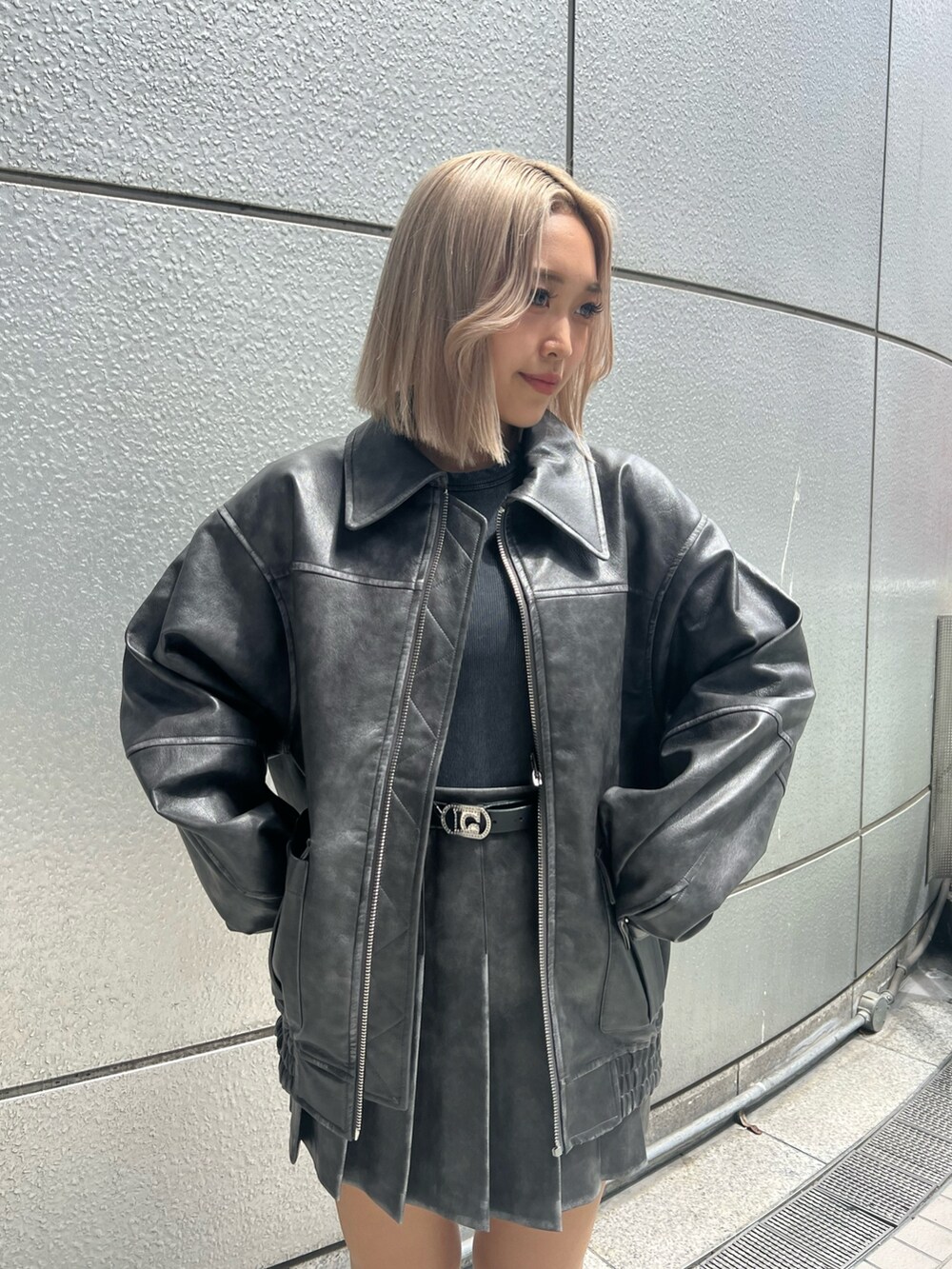 ブラック系のタンクトップ、グレー系のブルゾン、グレー系のスカートを着用したレディースの秋コーディネートの2枚目の写真