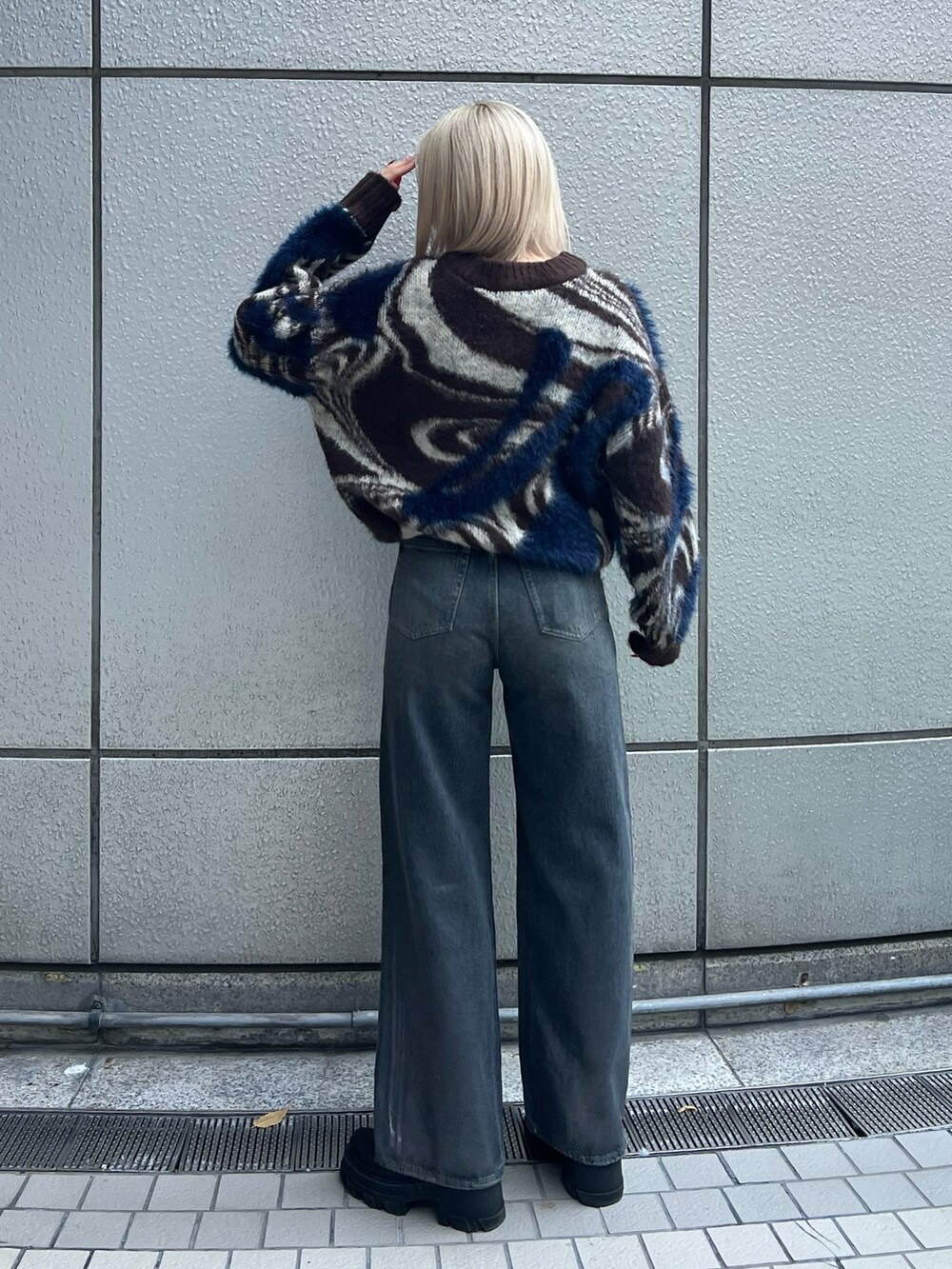 ブラウン系のニット/セーター、ブルー系のデニムパンツ、ブラック系のブーツを着用したレディースの冬コーディネートの3枚目の写真